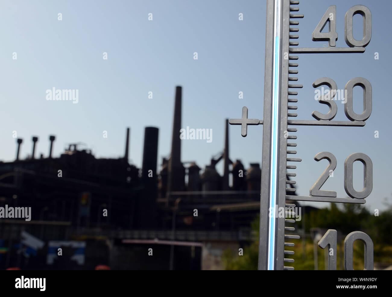 24 luglio 2019, Renania-Palatinato, Völklingen: il termometro nella parte anteriore del Sito del Patrimonio Culturale Mondiale Völklinger Hütte mostra oltre quaranta gradi al sole. Foto: Harald Tittel/dpa Foto Stock
