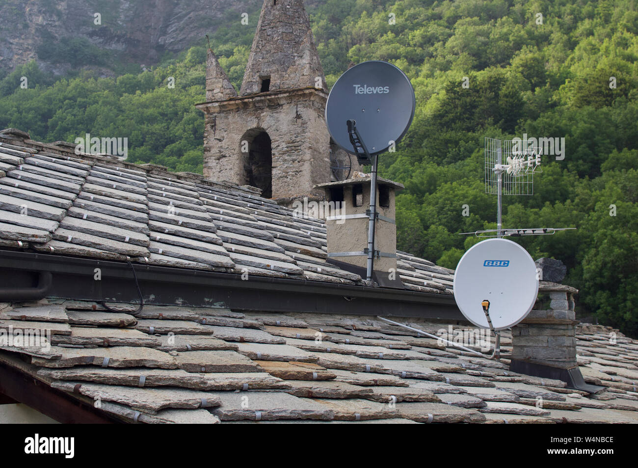 Antenne paraboliche sul tetto della vecchia casa in Montceniso Italia Foto Stock