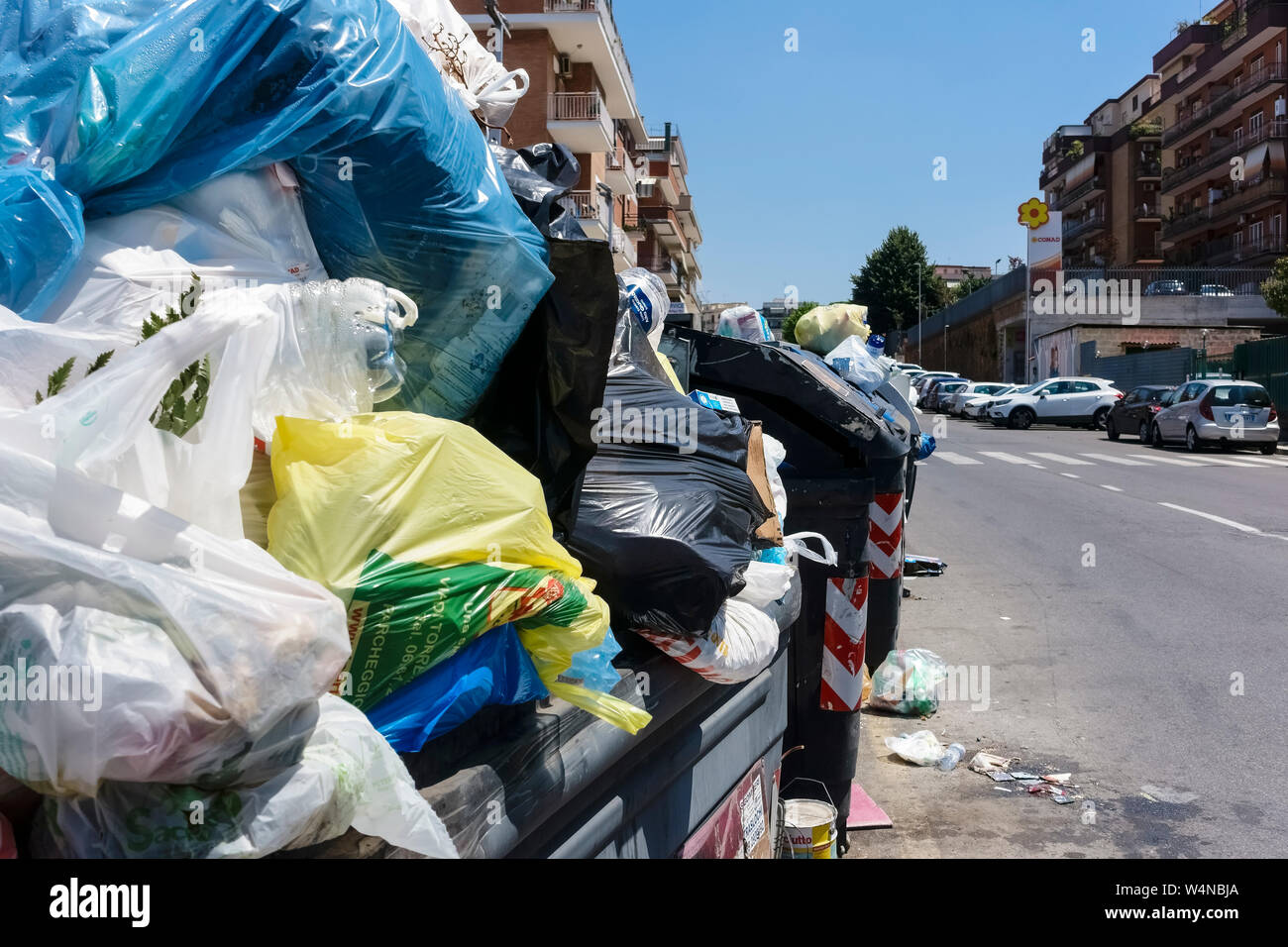 Cestino pieno di spazzatura davanti a edifici condominiali. Straripamento nel cestino della spazzatura contenitori. Incivility, maleducazione e sporcizia. Roma, Italia, Europa Foto Stock