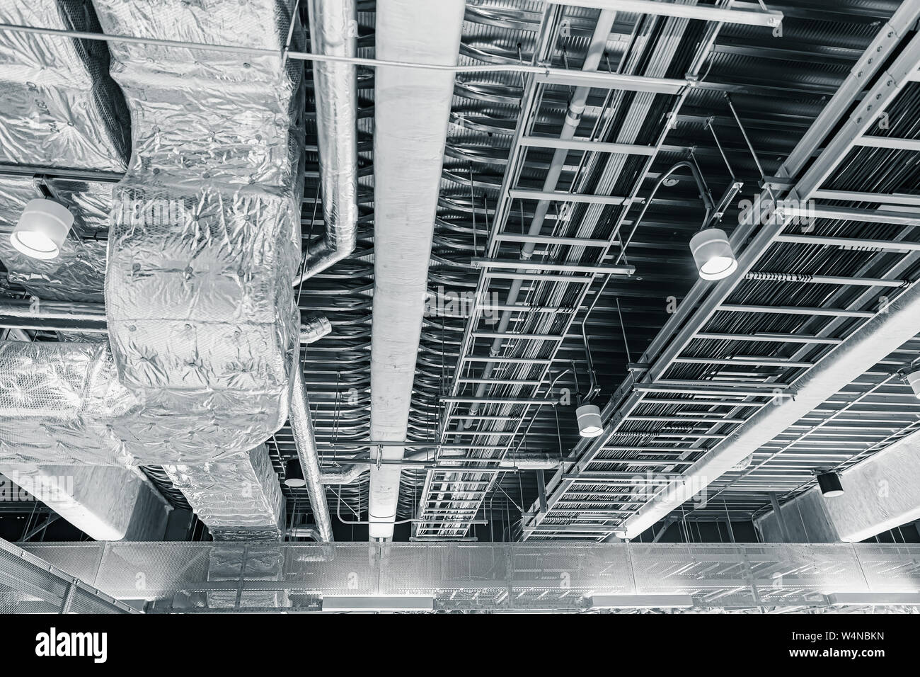 Il soffitto della tubazione dell'aria di ventilazione di aria e manged cavi dati in una funivia sul tetto di office Foto Stock