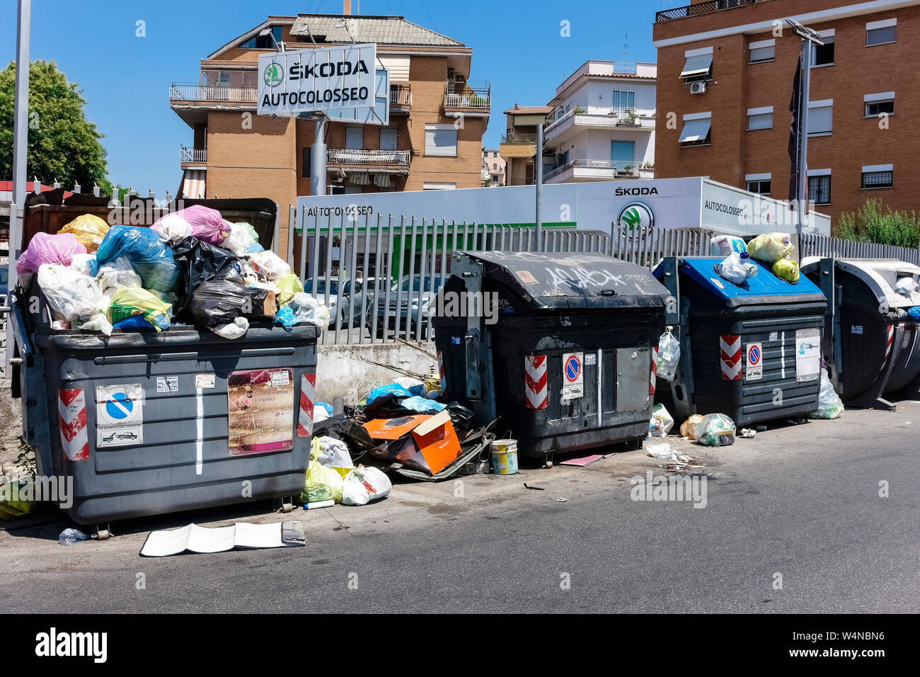 Cestino pieno di spazzatura davanti a edifici condominiali. Straripamento nel cestino della spazzatura contenitori. Incivility, maleducazione e sporcizia. Roma, Italia, Europa Foto Stock