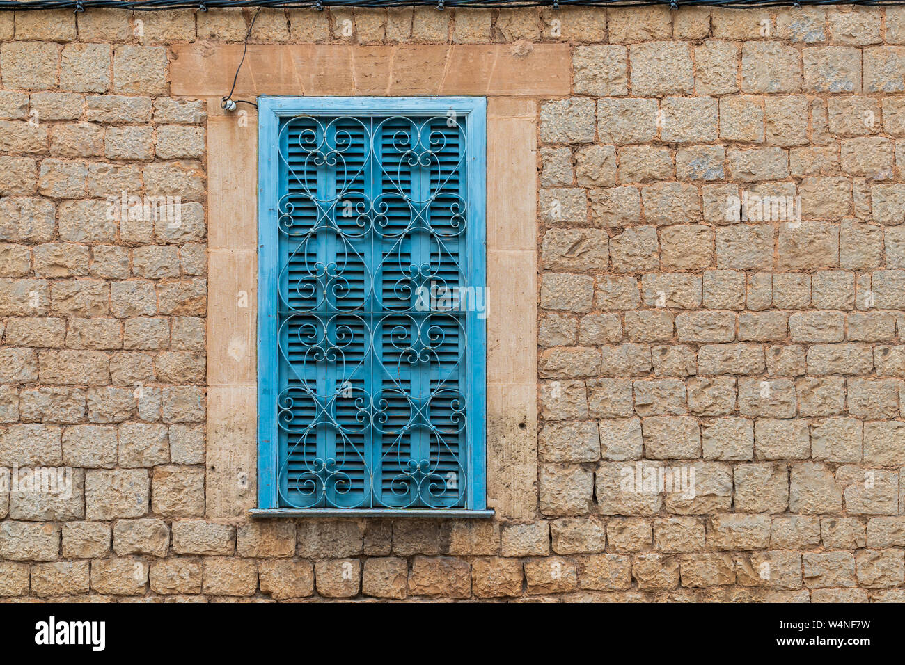 Persiane di turchese con il cuore a forma di reticolo di finestra in un muro di mattoni facciata di Valldemossa, Maiorca, Spagna - testa-su Vista, il formato orizzontale, cop Foto Stock