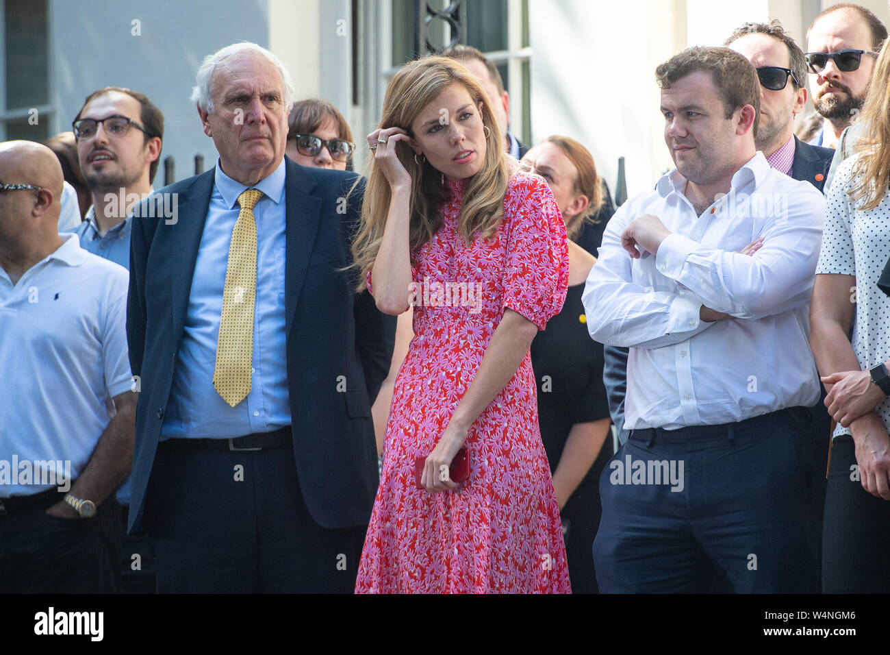 Il nuovo Primo Ministro Boris Johnson il partner Carrie Symonds attende per lui a fare un discorso al di fuori 10 Downing Street, Londra, dopo un incontro con la regina Elisabetta II e di accettare il suo invito a diventare Primo Ministro e formare un nuovo governo. Foto Stock