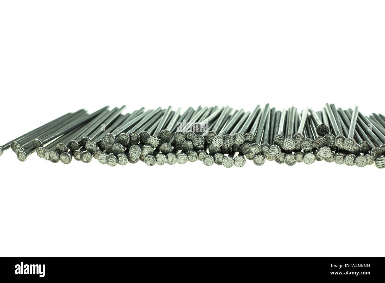 Pila di chiodi di ferro a sfondo bianco Foto Stock