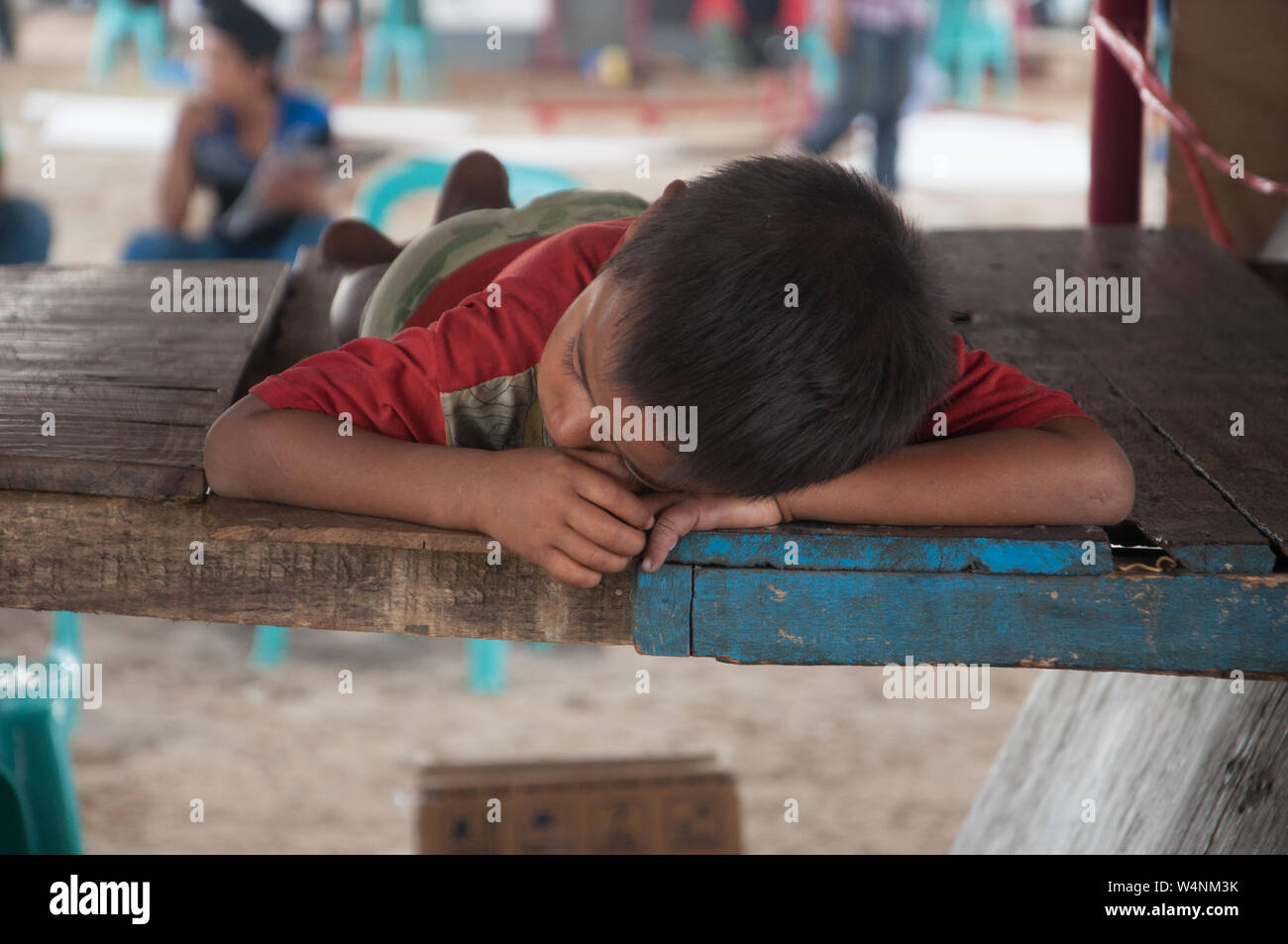 Street boy dorme su una piattaforma di legno. Foto Stock
