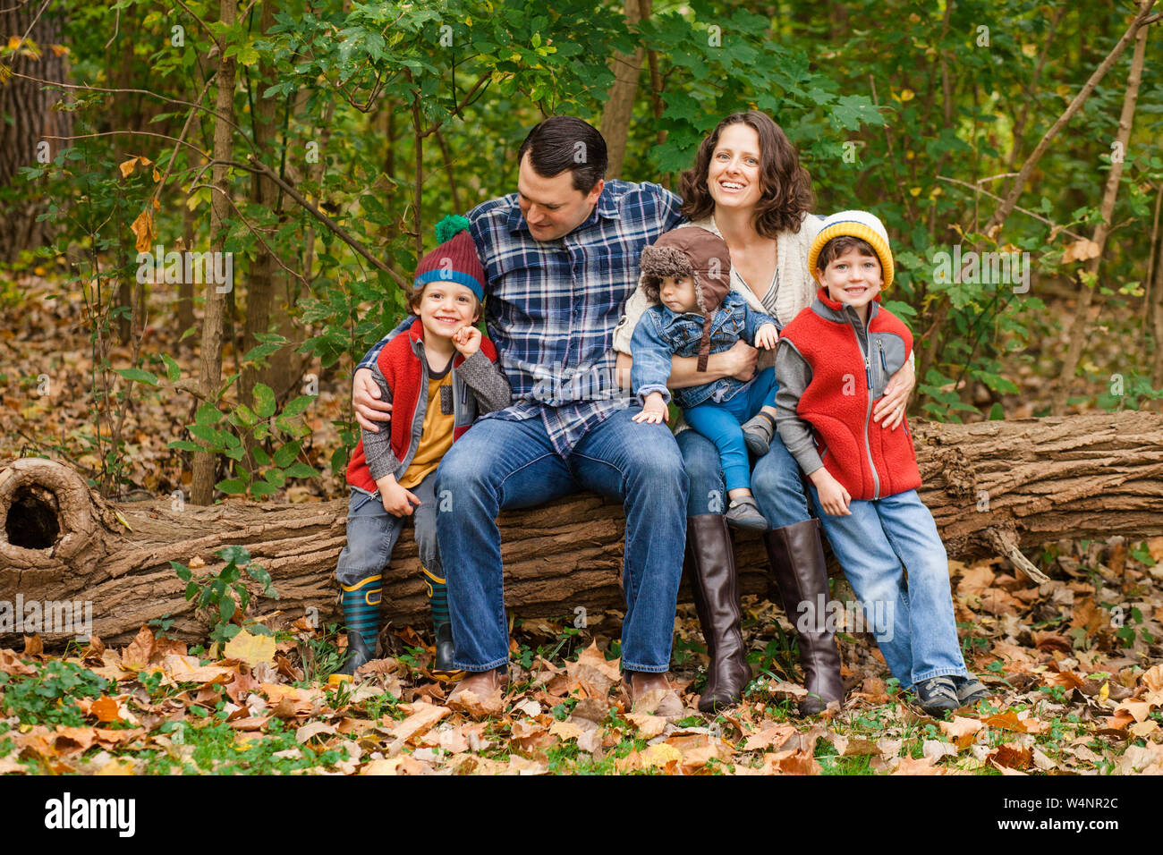 Ritratto di una famiglia seduti insieme in un parco boscoso Foto Stock