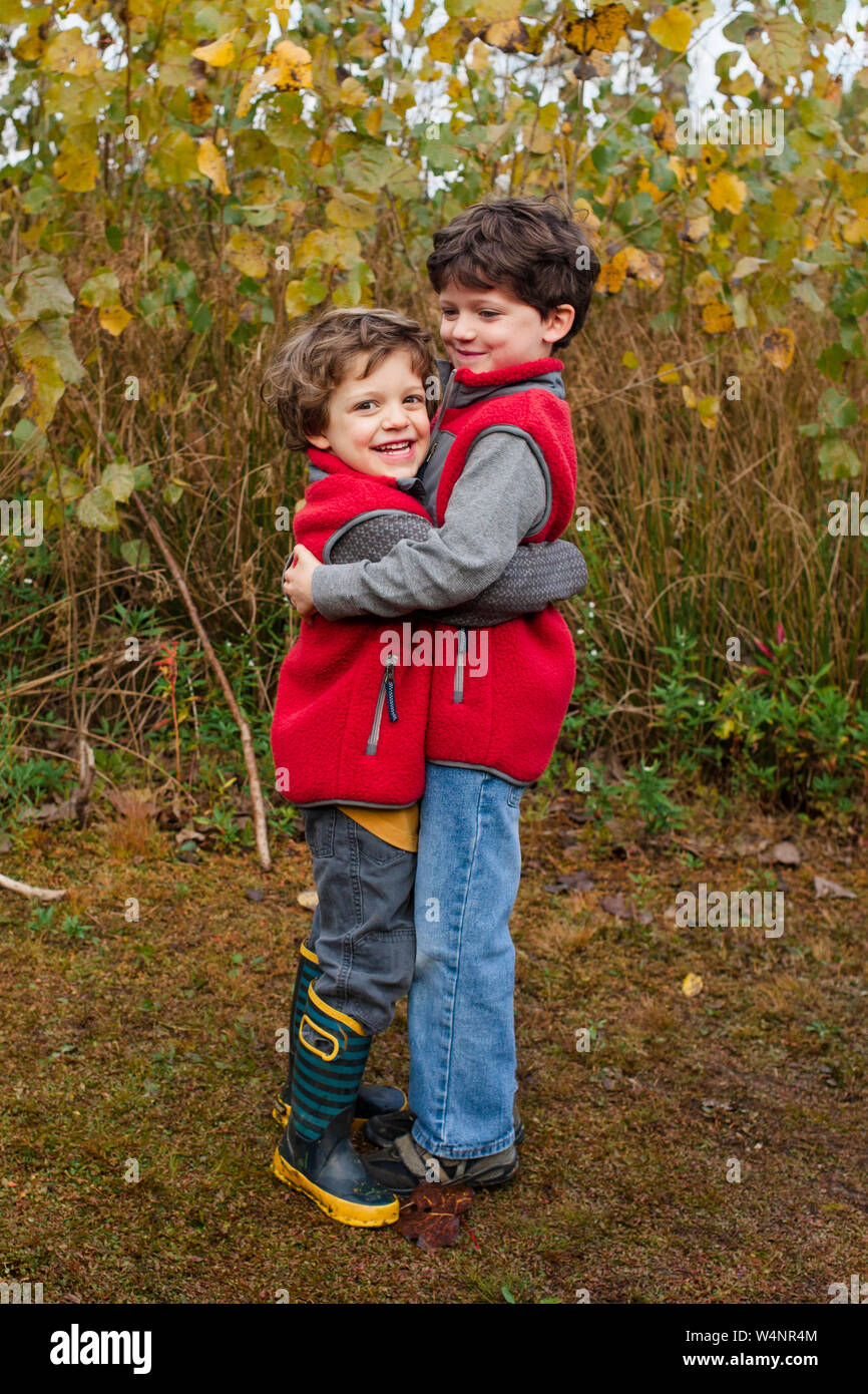 Due fratelli felice dare ad ogni altra un grande abbraccio all'aperto Foto Stock