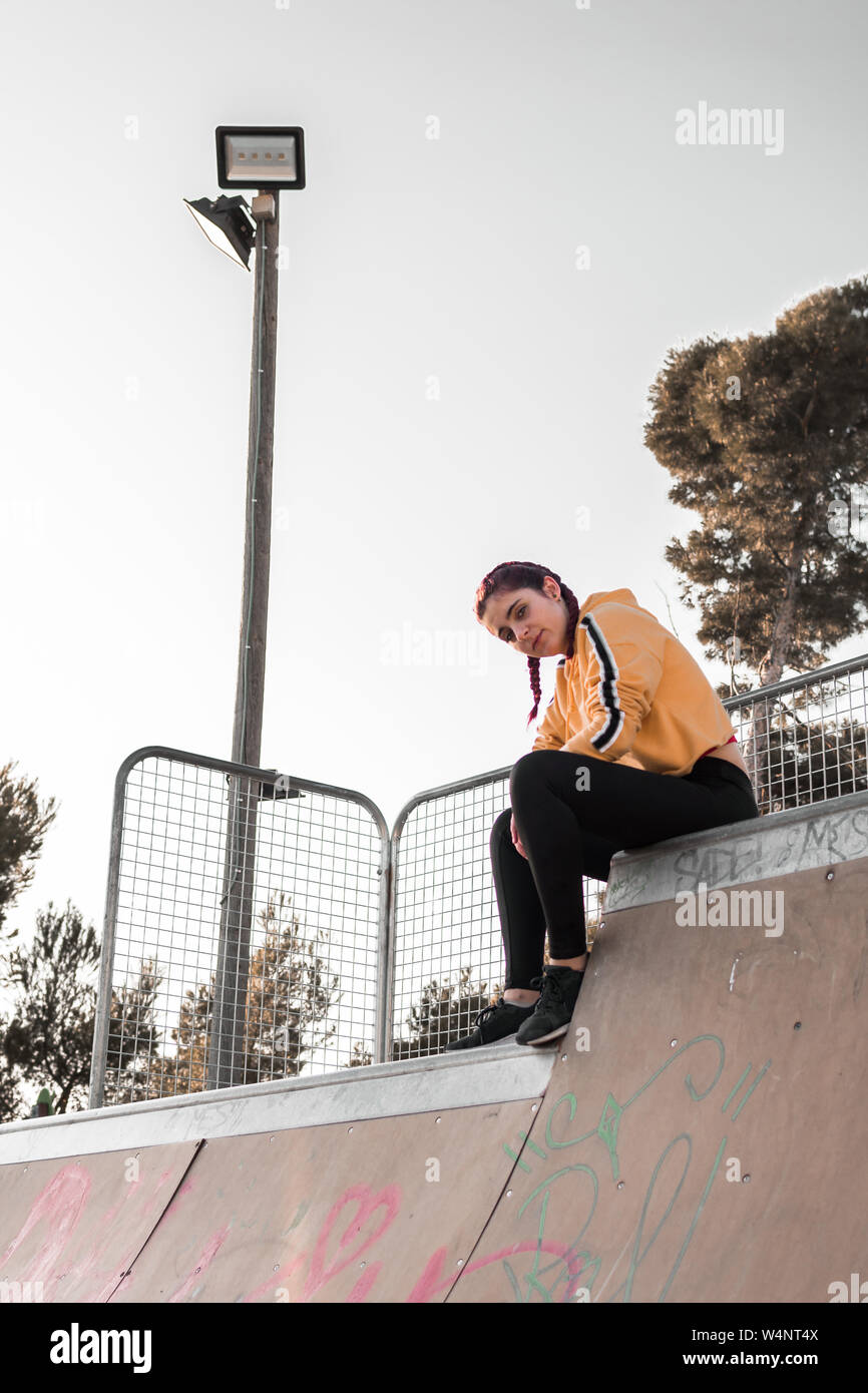 Giovane donna con vestiti di strada su una pista di pattinaggio. Il  concetto di stile di vita, skate Foto stock - Alamy