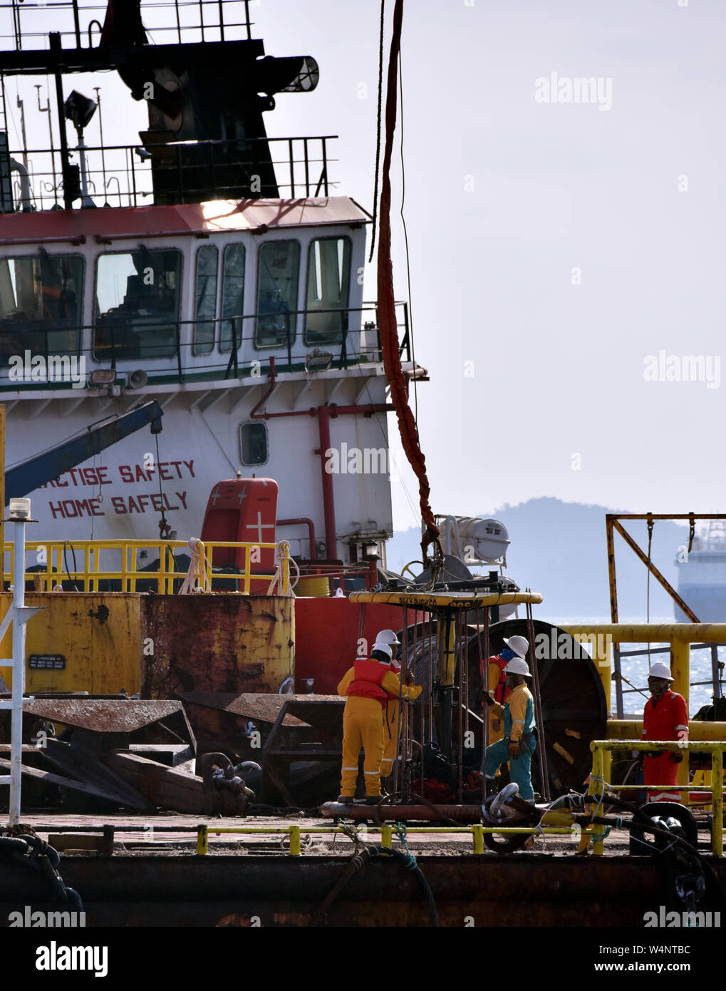 Equipaggio marino preparare cestello di sicurezza per piattaforma petrolifera persona essendo il trasferimento dal gruista Foto Stock