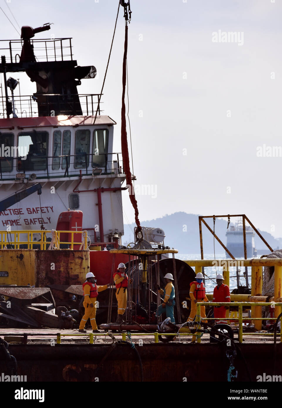 Equipaggio marino preparare cestello di sicurezza per piattaforma petrolifera persona essendo il trasferimento dal gruista Foto Stock