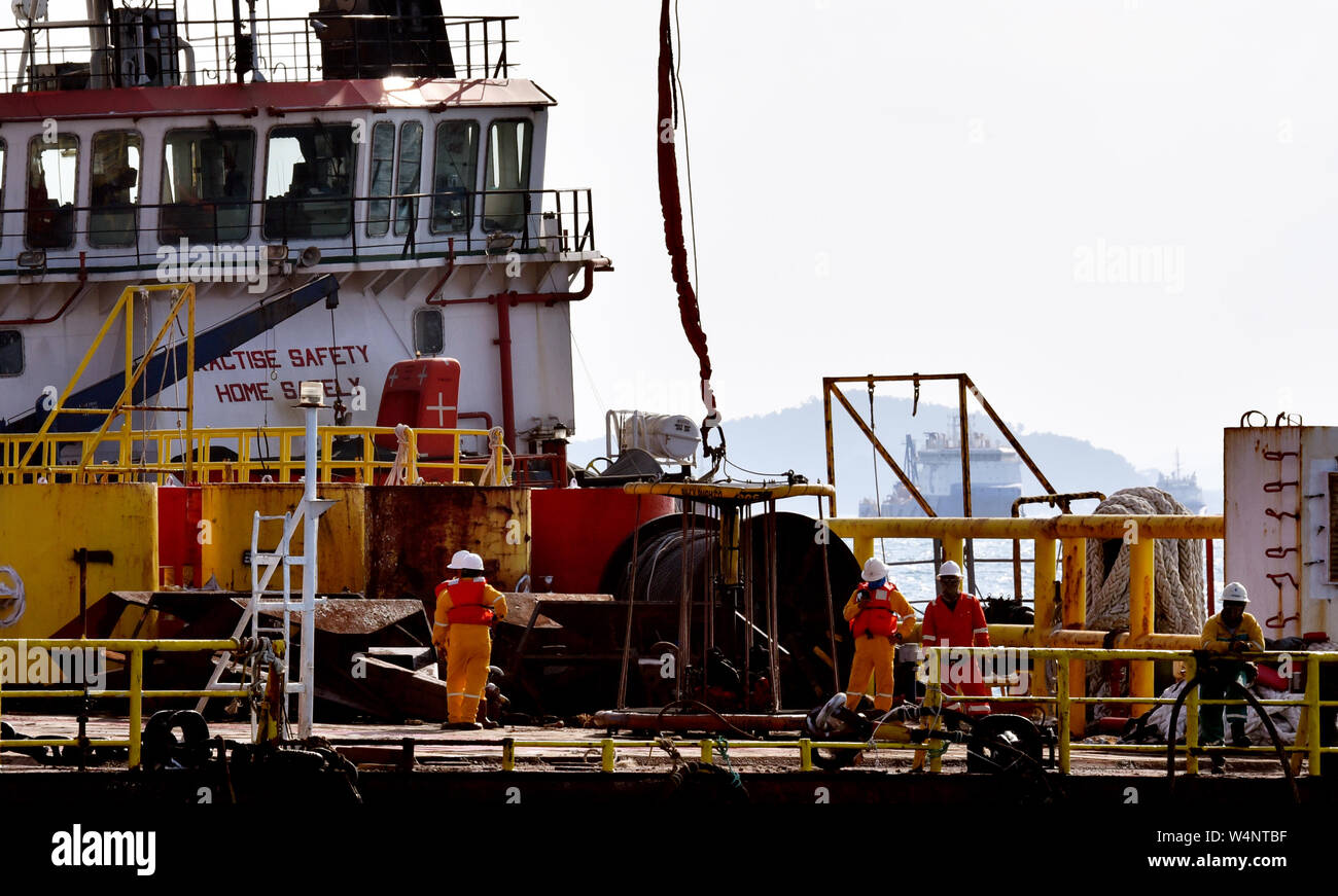 Equipaggio marino preparare cestello di sicurezza per piattaforma petrolifera persona essendo il trasferimento dal gruista Foto Stock