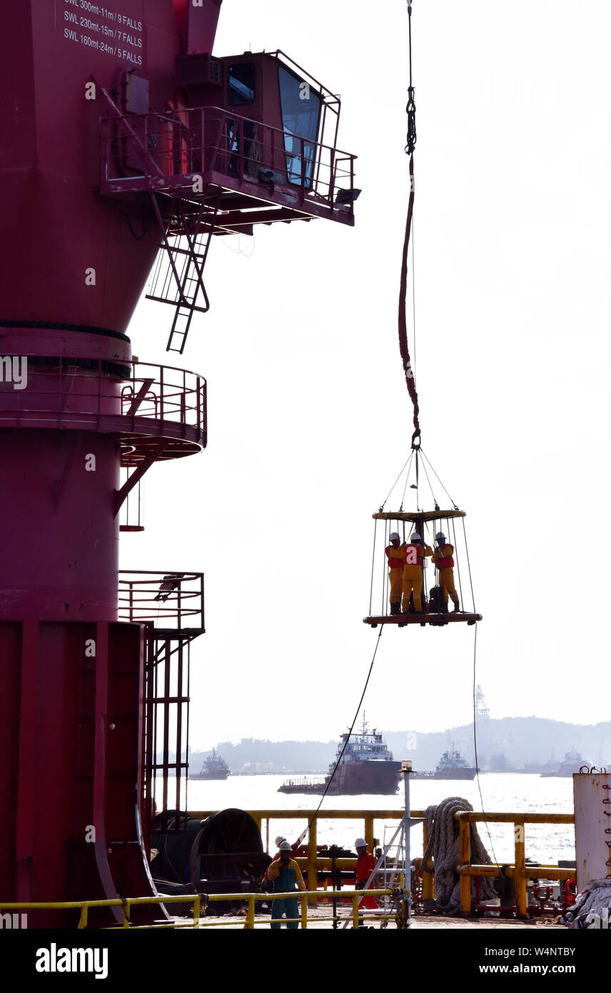 Offshore di trasferimento di personale con cesto di sicurezza operano tramite il gruista Foto Stock