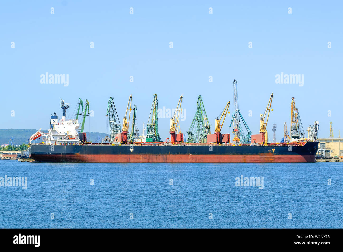 Varna, Bulgaria, 22 luglio 2019. Grande rosso nero mare nave da carico mentre il parcheggio nel porto. Gru portuali scaricare il carico nella nave. Foto Stock