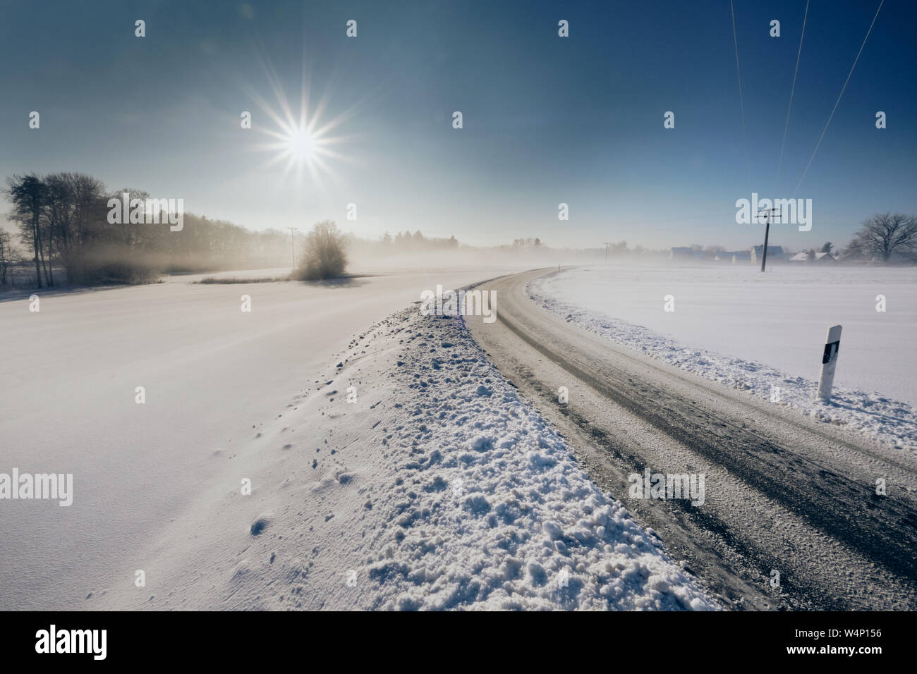 Icy strada di campagna con una prospettiva dimishing su un inverno pieno di sole monrning. Visto nei pressi del villaggio di Unterhaidelbach in Germania Foto Stock
