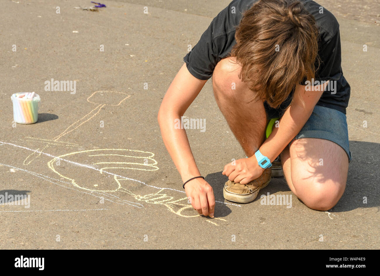 CARDIFF, GALLES - Luglio 2019: attivista prendendo parte al clima di protesta di emergenza dalla ribellione di estinzione a Cardiff il disegno di immagini sul terreno. Foto Stock