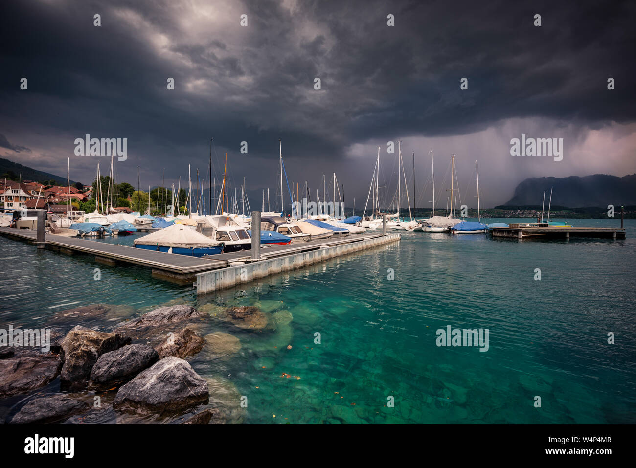 Hilterfingen marina in una luce brillante, scuro meteo anteriori con sensore pioggia in background Foto Stock