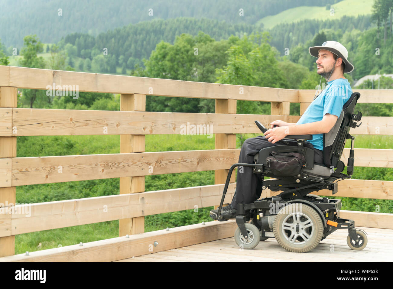 Disabilitato giovane in sedia elettrica su un lungomare godendo della sua libertà e della sua osservazione della natura Foto Stock