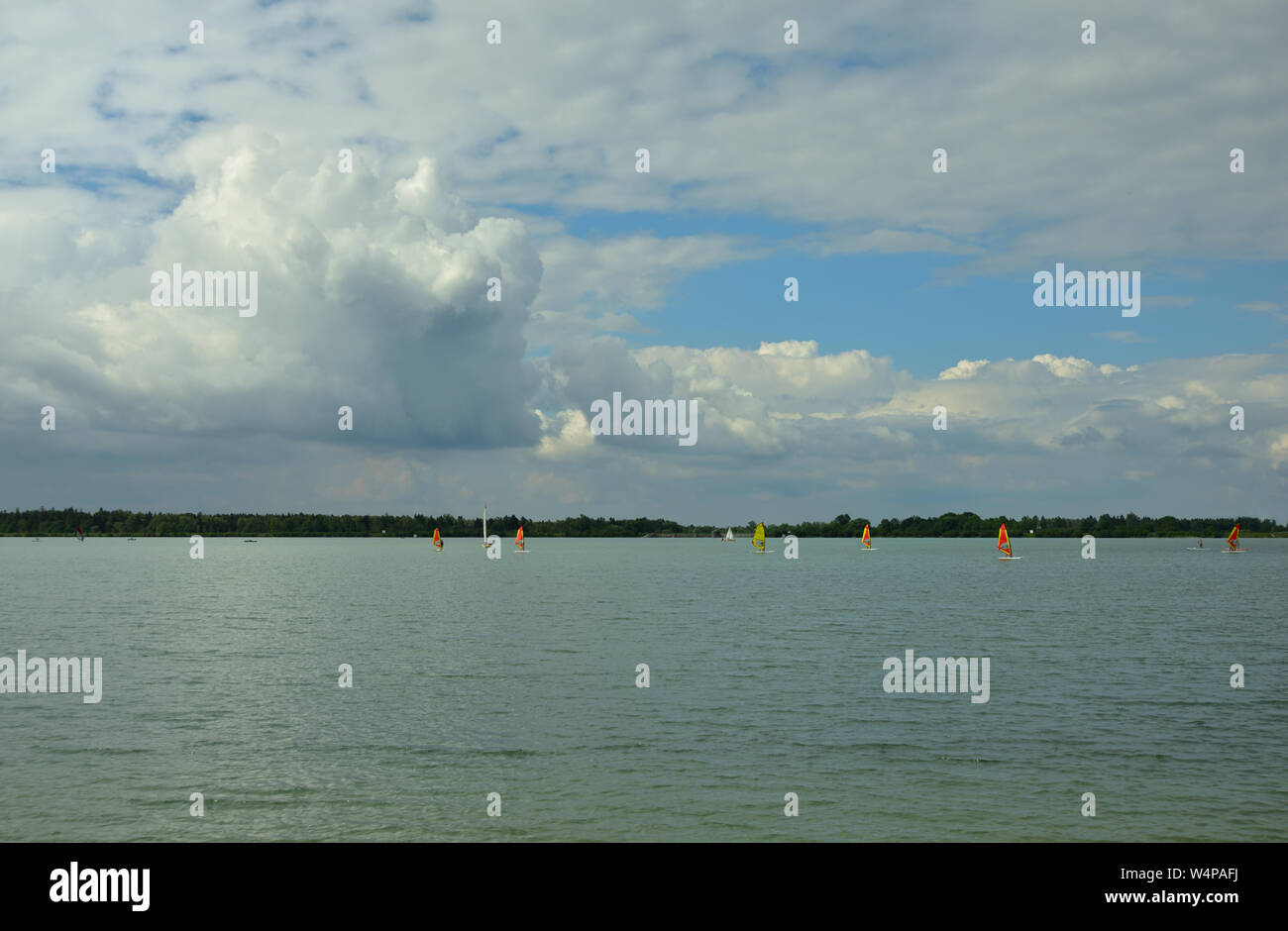 Sullo sfondo di un lago balneabile con piccole barche a vela e il cielo con le nuvole Foto Stock