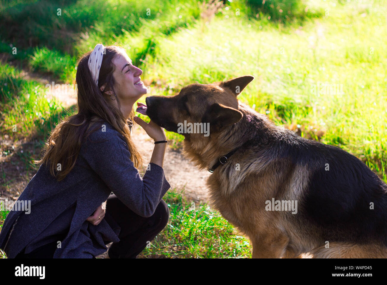 Ragazza baciare con il suo cane nella natura Foto Stock