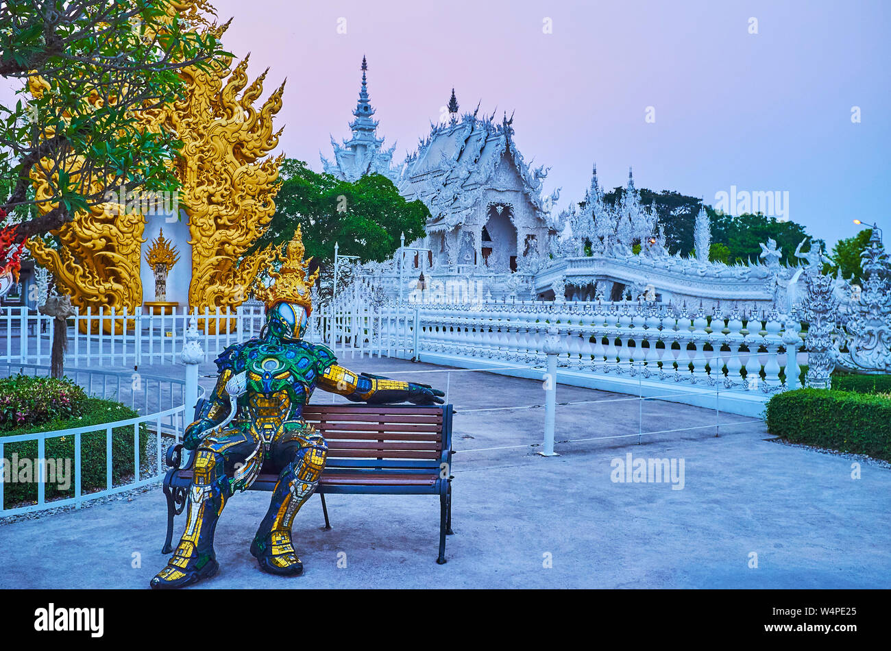 CHIANG RAI, Tailandia - 9 Maggio 2019: stile tailandese robot si siede sul banco di fronte alla sera bianco (tempio Wat Rongkhun), il 9 maggio in Chiang Rai Foto Stock