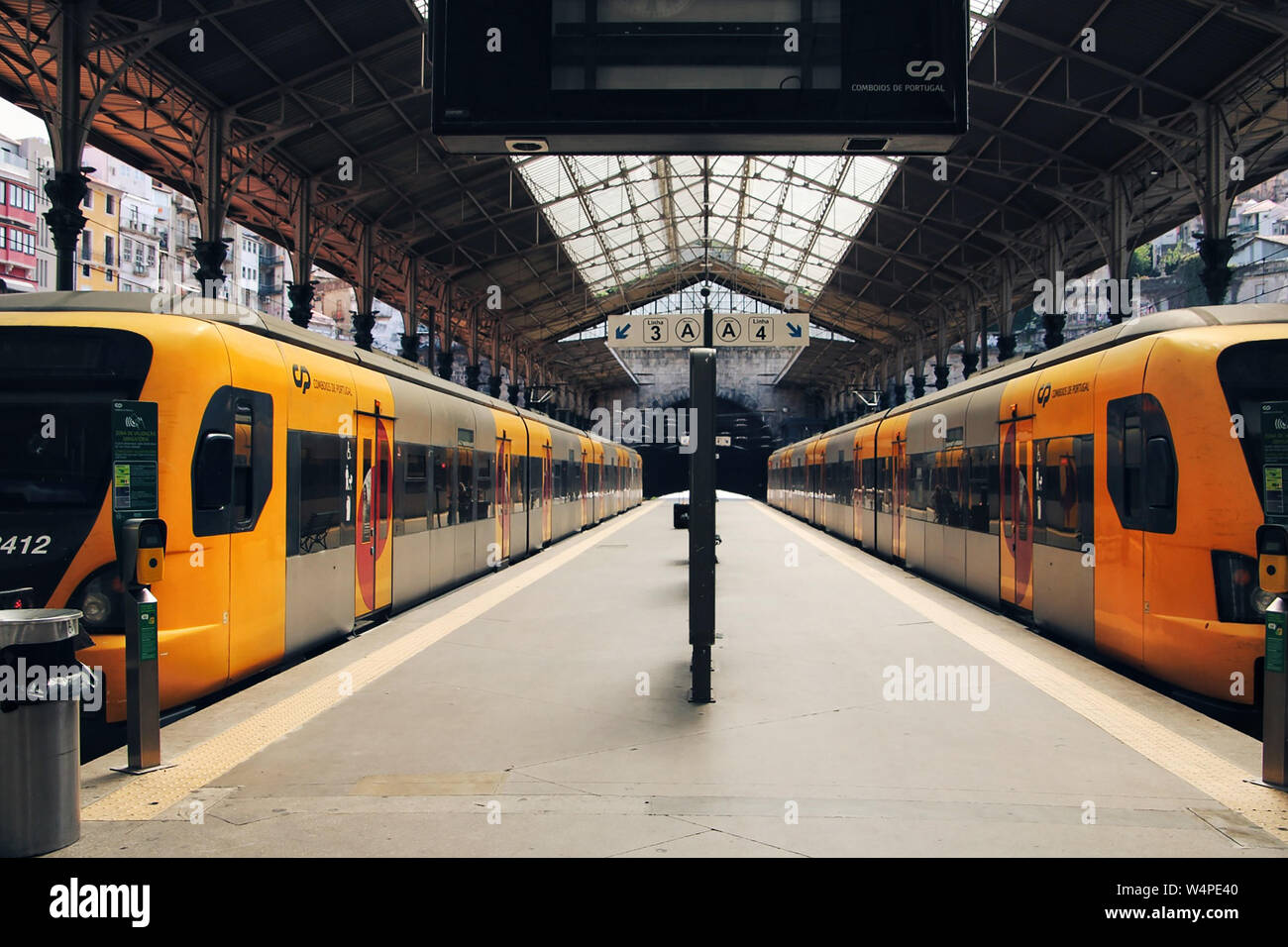Stazione ferroviaria con due treni di giallo. Foto Stock