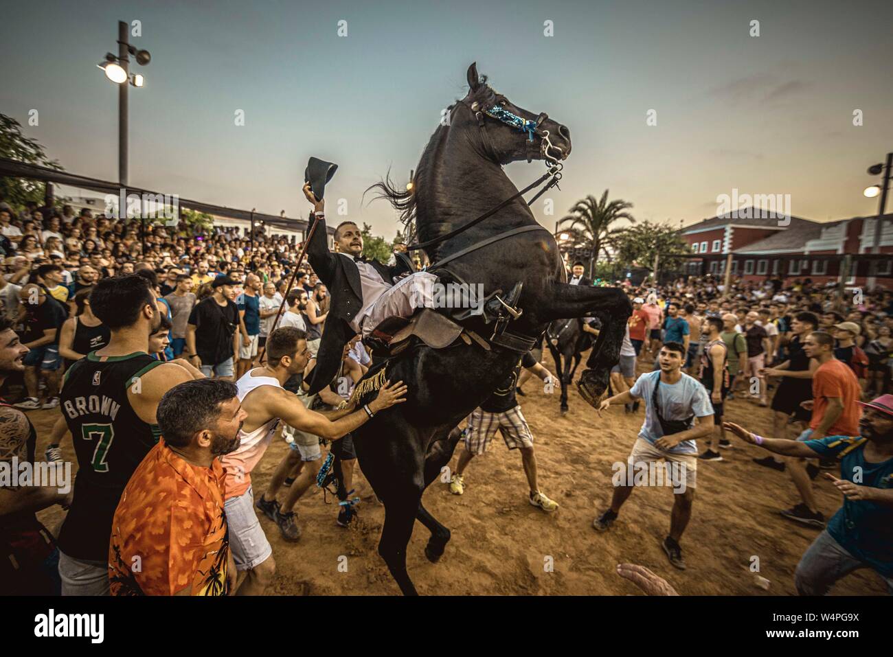 Barcellona, Spagna. 24 Luglio 2019: un 'caixer' (cavallo Cavaliere) culatte fino sul suo cavallo circondato da un tifo folla durante il tradizionale "Jaleo al Sant Jaume Festival in Es Castell Credito: Matthias Oesterle/Alamy Live News Foto Stock