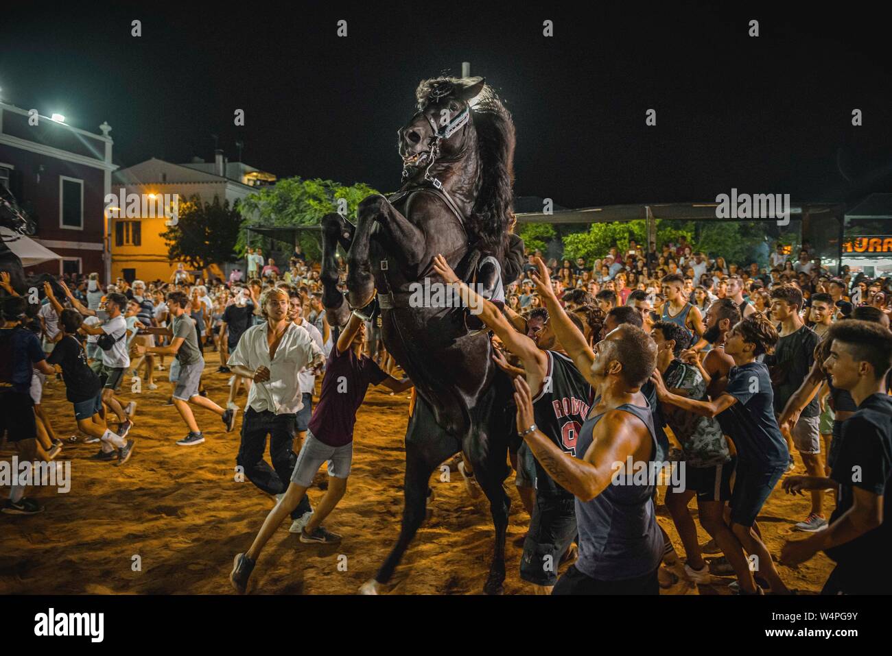 Barcellona, Spagna. 24 Luglio 2019: un 'caixer' (cavallo Cavaliere) culatte fino sul suo cavallo circondato da un tifo folla durante il tradizionale "Jaleo al Sant Jaume Festival in Es Castell Credito: Matthias Oesterle/Alamy Live News Foto Stock
