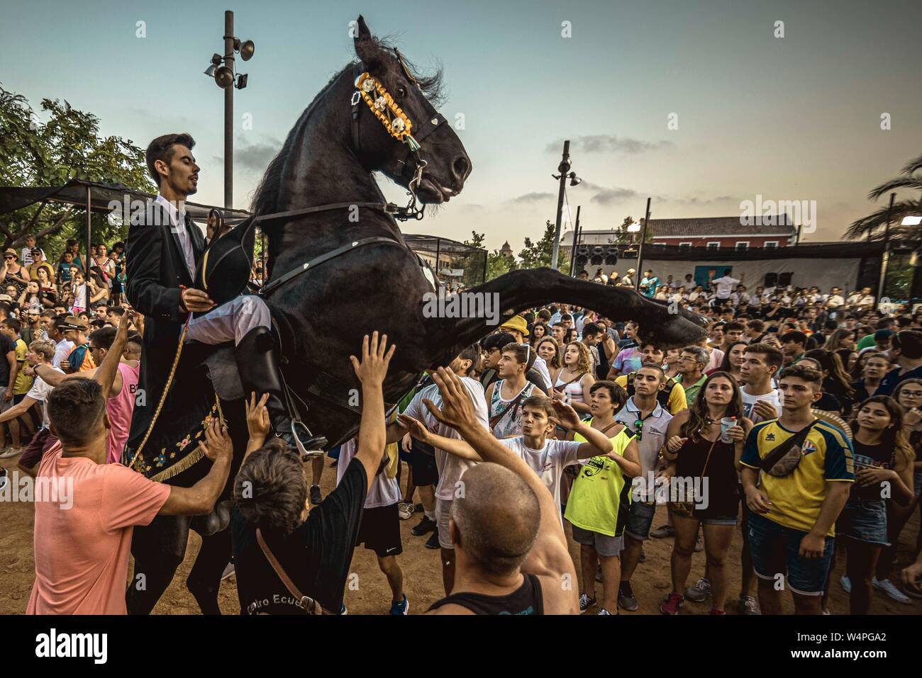 Barcellona, Spagna. 24 Luglio 2019: un 'caixer' (cavallo Cavaliere) culatte fino sul suo cavallo circondato da un tifo folla durante il tradizionale "Jaleo al Sant Jaume Festival in Es Castell Credito: Matthias Oesterle/Alamy Live News Foto Stock