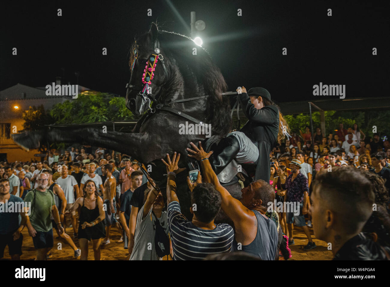 Barcellona, Spagna. 24 Luglio 2019: un 'caixer' (cavallo Cavaliere) culatte fino sul suo cavallo circondato da un tifo folla durante il tradizionale "Jaleo al Sant Jaume Festival in Es Castell Credito: Matthias Oesterle/Alamy Live News Foto Stock