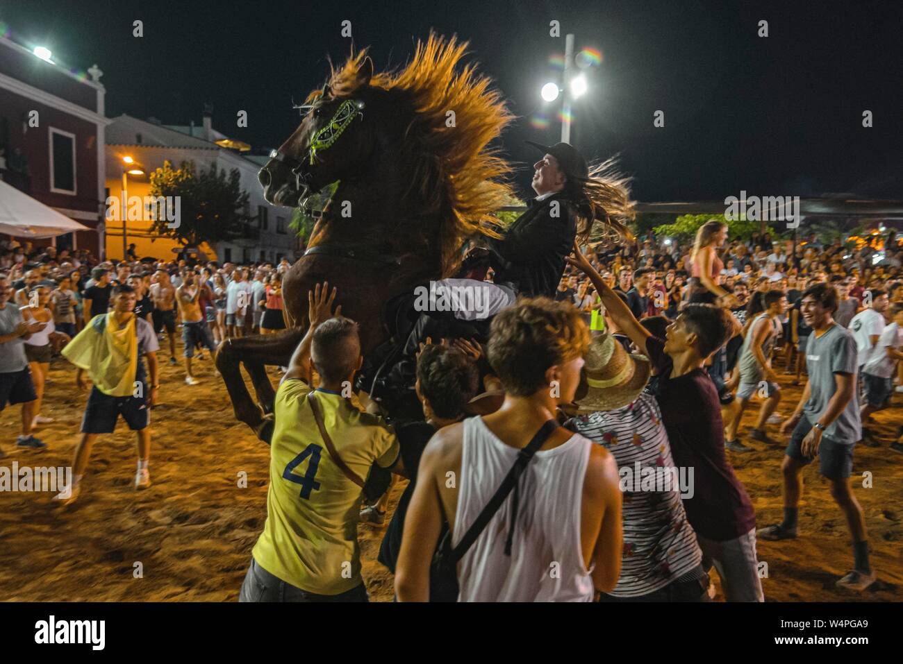 Barcellona, Spagna. 24 Luglio 2019: un 'caixer' (cavallo Cavaliere) culatte fino sul suo cavallo circondato da un tifo folla durante il tradizionale "Jaleo al Sant Jaume Festival in Es Castell Credito: Matthias Oesterle/Alamy Live News Foto Stock