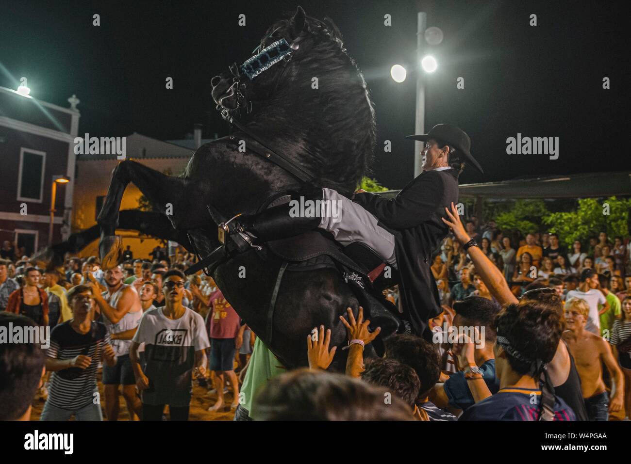 Barcellona, Spagna. 24 Luglio 2019: un 'caixer' (cavallo Cavaliere) culatte fino sul suo cavallo circondato da un tifo folla durante il tradizionale "Jaleo al Sant Jaume Festival in Es Castell Credito: Matthias Oesterle/Alamy Live News Foto Stock