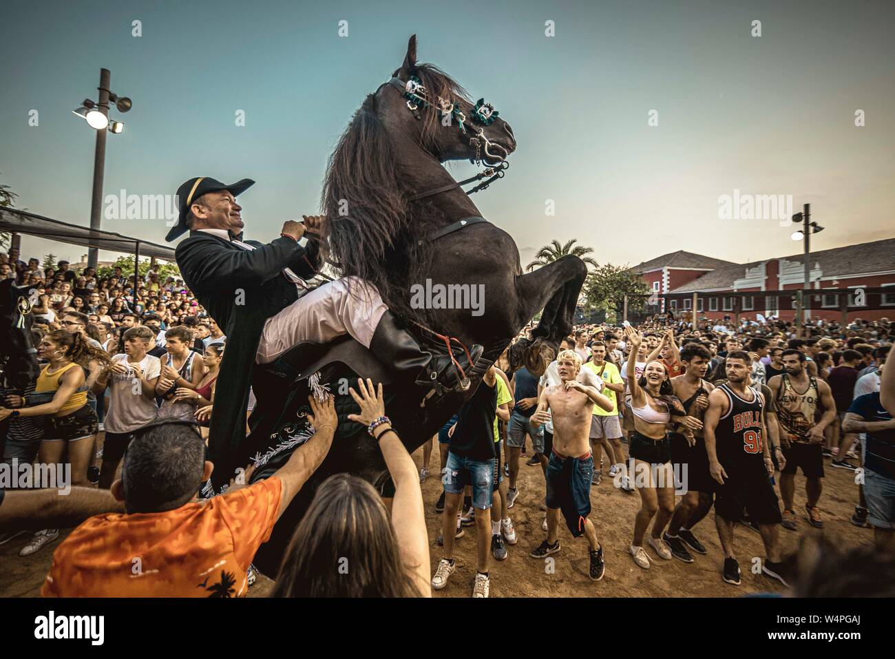 Barcellona, Spagna. 24 Luglio 2019: un 'caixer' (cavallo Cavaliere) culatte fino sul suo cavallo circondato da un tifo folla durante il tradizionale "Jaleo al Sant Jaume Festival in Es Castell Credito: Matthias Oesterle/Alamy Live News Foto Stock