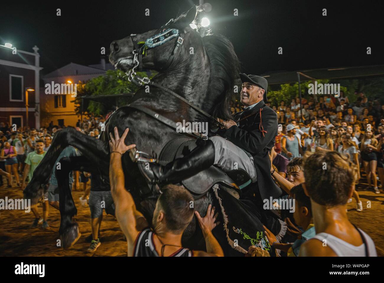Barcellona, Spagna. 24 Luglio 2019: un 'caixer' (cavallo Cavaliere) culatte fino sul suo cavallo circondato da un tifo folla durante il tradizionale "Jaleo al Sant Jaume Festival in Es Castell Credito: Matthias Oesterle/Alamy Live News Foto Stock