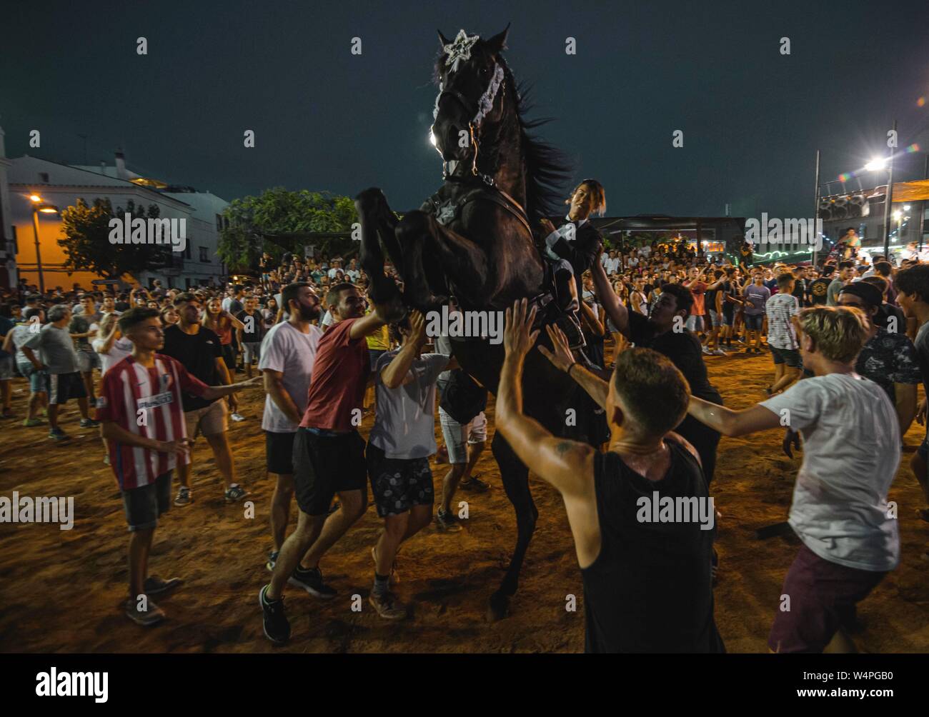 Barcellona, Spagna. 24 Luglio 2019: un 'caixer' (cavallo Cavaliere) culatte fino sul suo cavallo circondato da un tifo folla durante il tradizionale "Jaleo al Sant Jaume Festival in Es Castell Credito: Matthias Oesterle/Alamy Live News Foto Stock