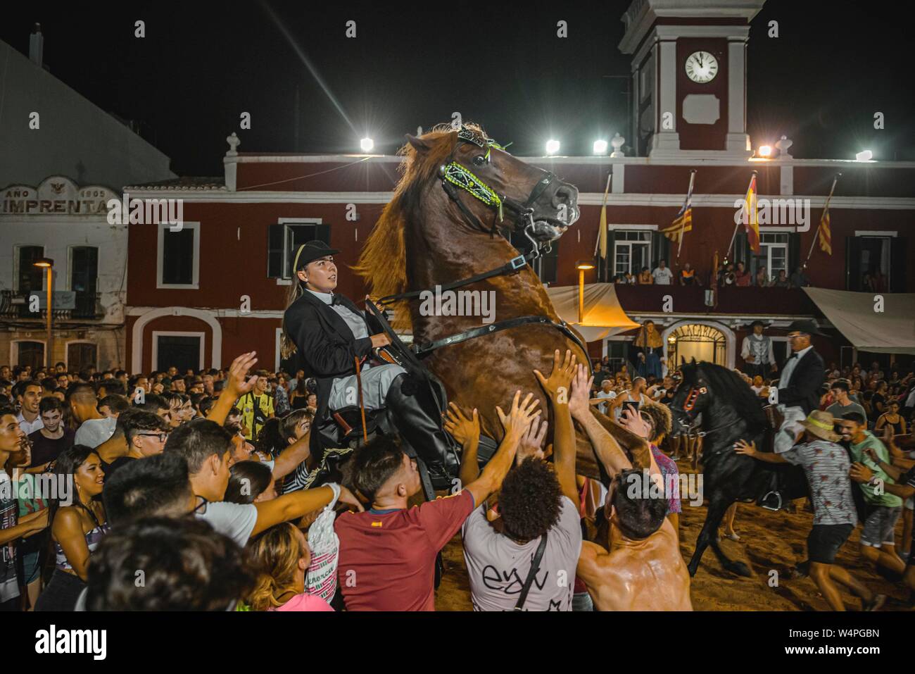 Barcellona, Spagna. 24 Luglio 2019: un 'caixer' (cavallo Cavaliere) culatte fino sul suo cavallo circondato da un tifo folla durante il tradizionale "Jaleo al Sant Jaume Festival in Es Castell Credito: Matthias Oesterle/Alamy Live News Foto Stock