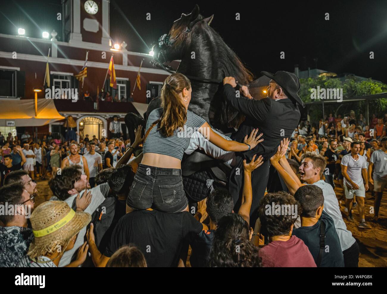 Barcellona, Spagna. 24 Luglio 2019: un 'caixer' (cavallo Cavaliere) culatte fino sul suo cavallo circondato da un tifo folla durante il tradizionale "Jaleo al Sant Jaume Festival in Es Castell Credito: Matthias Oesterle/Alamy Live News Foto Stock