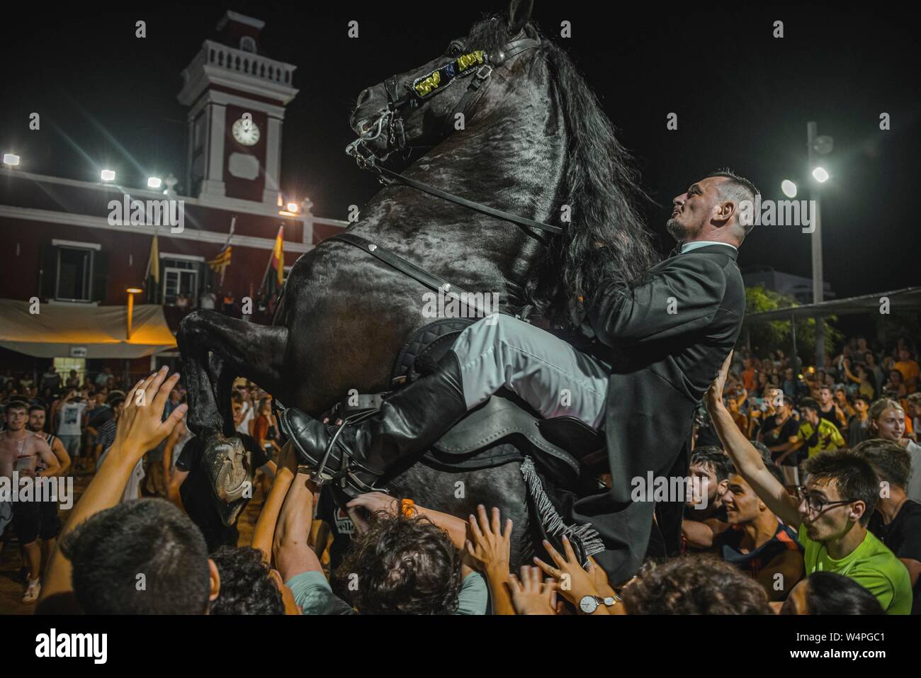 Barcellona, Spagna. 24 Luglio 2019: un 'caixer' (cavallo Cavaliere) culatte fino sul suo cavallo circondato da un tifo folla durante il tradizionale "Jaleo al Sant Jaume Festival in Es Castell Credito: Matthias Oesterle/Alamy Live News Foto Stock