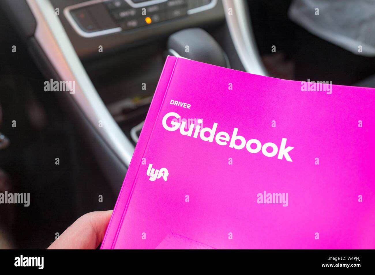Close-up della mano di un uomo con una rosa autista guida per crowdsourced taxi company Lyft all'interno di un abitacolo di un veicolo Lyft in San Ramon, California, 27 settembre 2018. () Foto Stock
