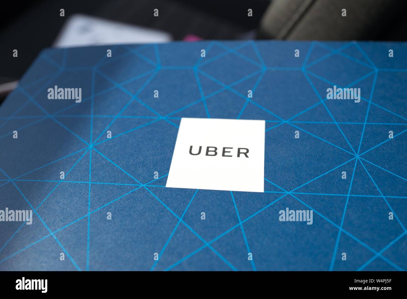 Close-up di logo per Uber sull'azzurro stampato sullo sfondo di un conducente rilasciato manuale per i nuovi driver dal crowdsourced servizio taxi Uber, in un veicolo Uber in San Ramon, California, 27 settembre 2018. () Foto Stock