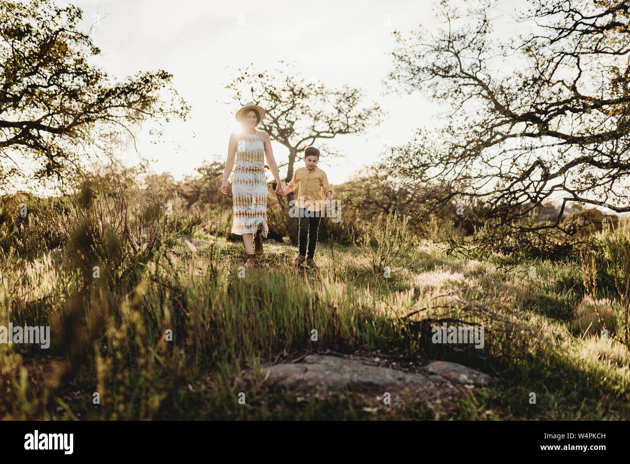 Vista frontale della madre e del figlio tenendo le mani e piedi al di fuori Foto Stock