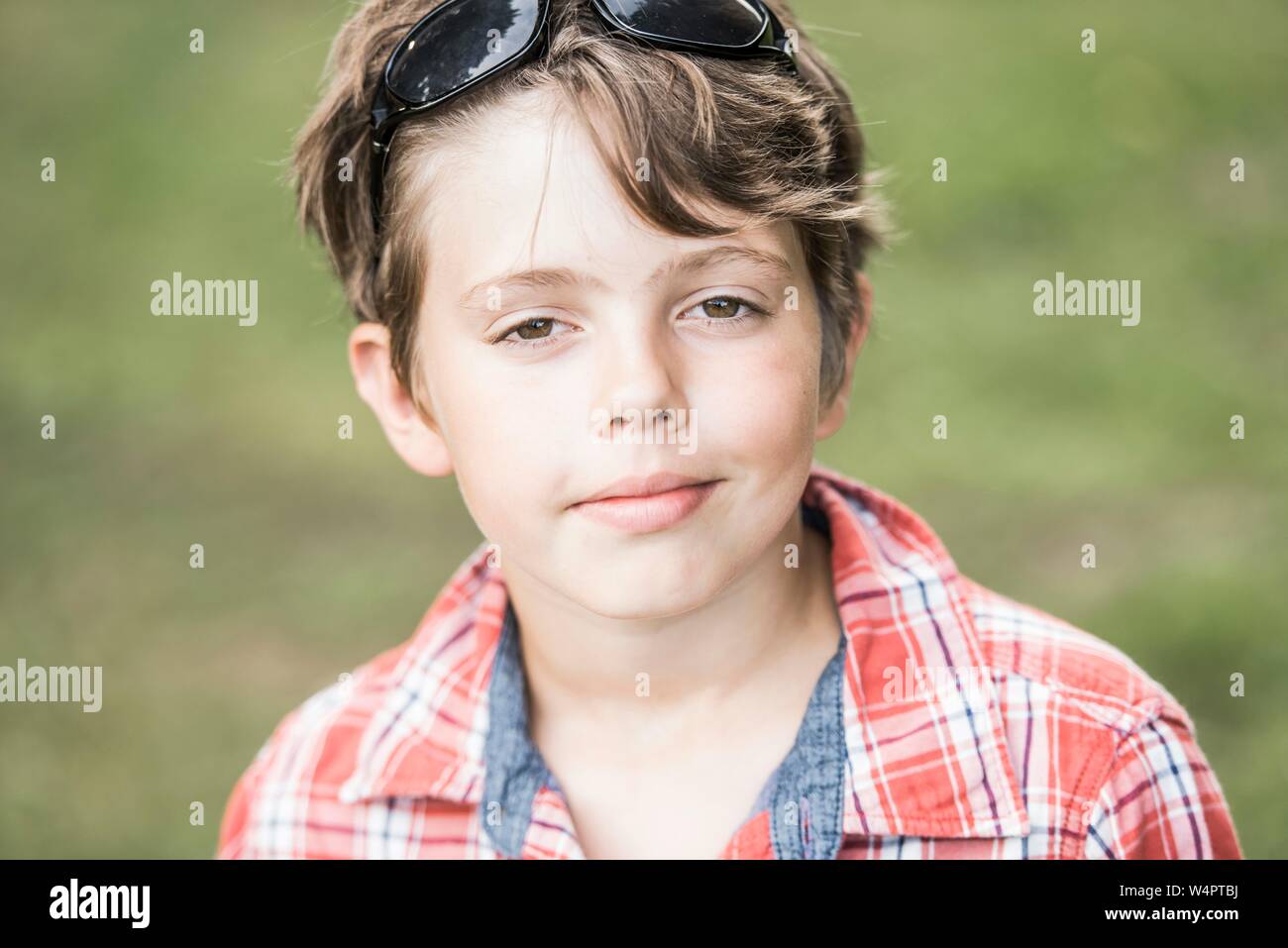 Ragazzo, dieci anni, con occhiali da sole e plaid camicia guarda raffreddare nella fotocamera, Ritratto, Germania Foto Stock