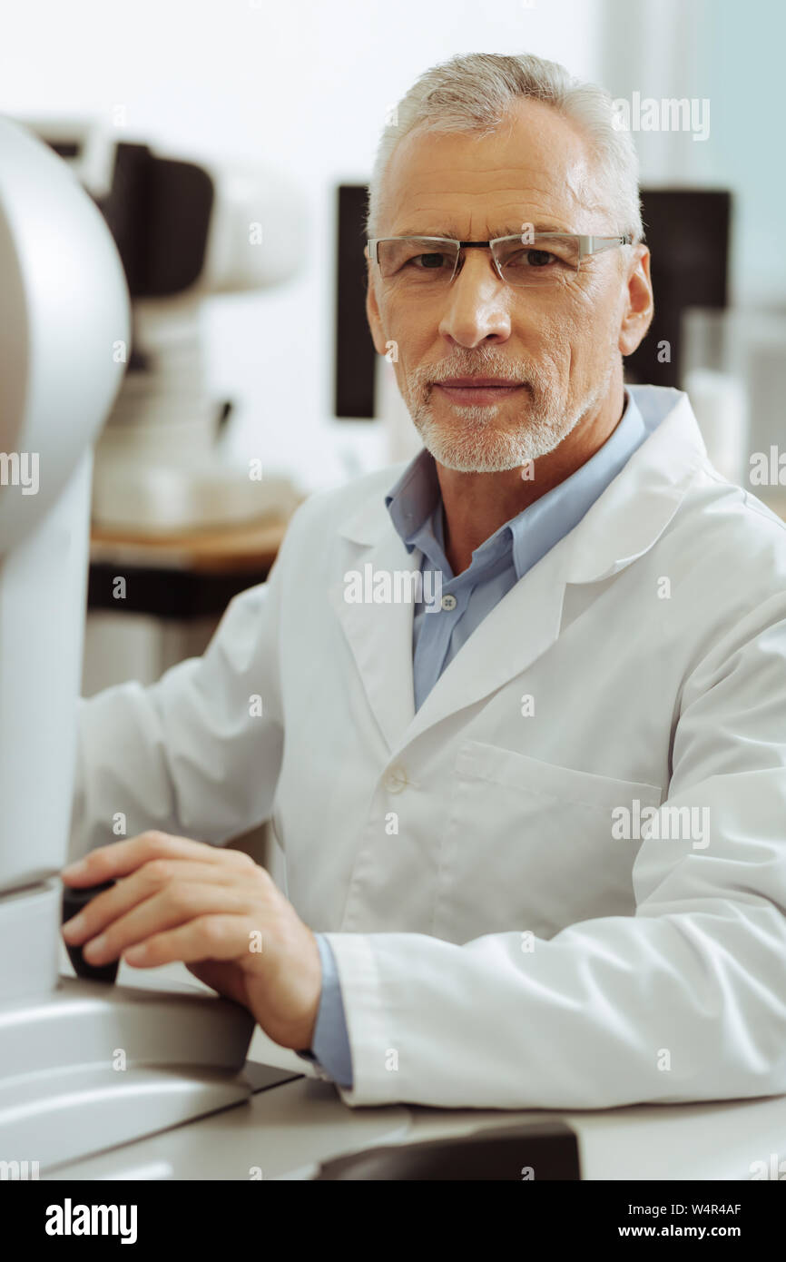 Occhio esperto medico. Professional occhio esperto medico che indossano uniformi di seduta al tavolo Foto Stock