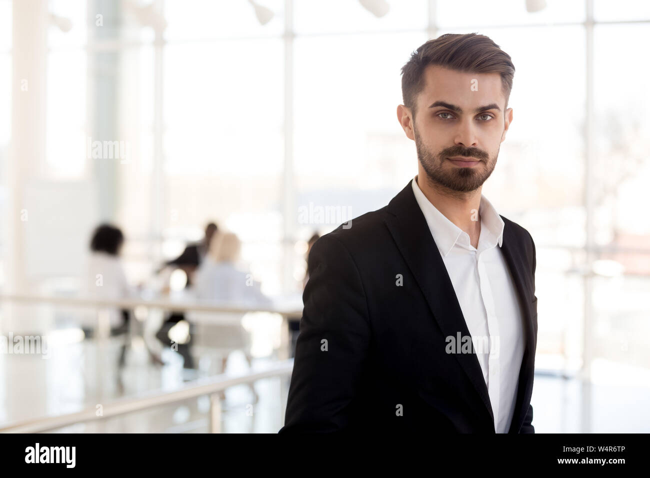 Colpo alla testa ritratto imprenditore fiducioso in tuta in posa di corridoio Foto Stock