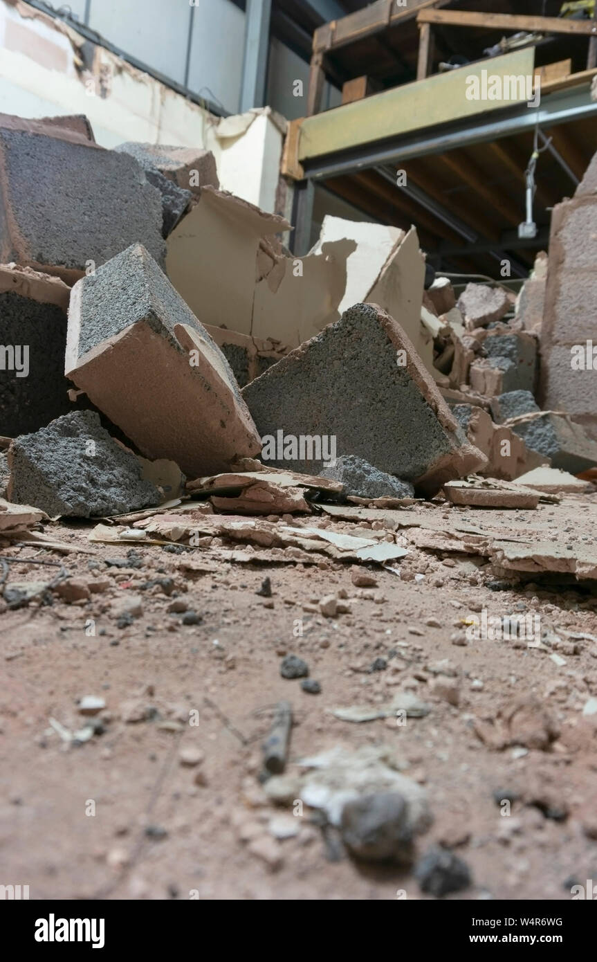 Demolita breeze blocco parete interna all'interno di una fabbrica. Parte di un progetto di ricostruzione. Sito di costruzione macerie Foto Stock