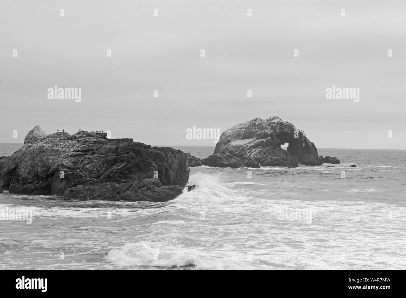 Immagine in bianco e nero di un cuore foro sagomato in una roccia lungo la costa Californiana. Foto Stock