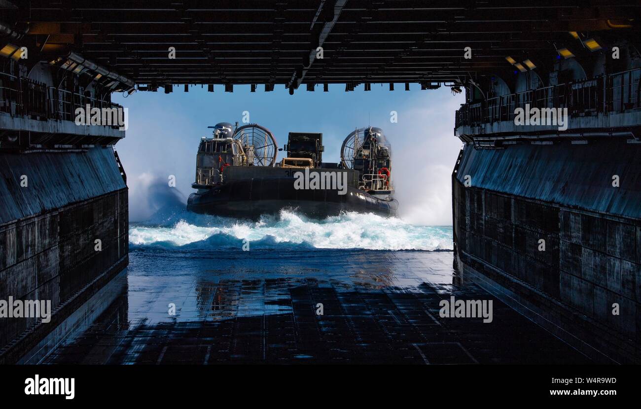 190724-N-BK435-0104 CORAL SEA (Luglio 24, 2019) - Landing Craft, cuscino d'aria (LCAC) 30, assegnato alla spiaggia navale unità (NBU) 7, entra nel ben coperta dell'assalto anfibio nave USS Wasp (LHD 1). Wasp, ammiraglia di Wasp Expeditionary Strike gruppo, con avviato 31 Marine Expeditionary Unit, partecipa attualmente a Talisman Sabre 2019 al largo delle coste del nord Australia. Un accordo bilaterale, evento biennale, Talisman Sabre è progettato per migliorare NEGLI STATI UNITI Australia e combattere la formazione, la disponibilità e l' interoperabilità attraverso l' realistico, formazione pertinenti necessarie per mantenere la sicurezza regionale, Foto Stock