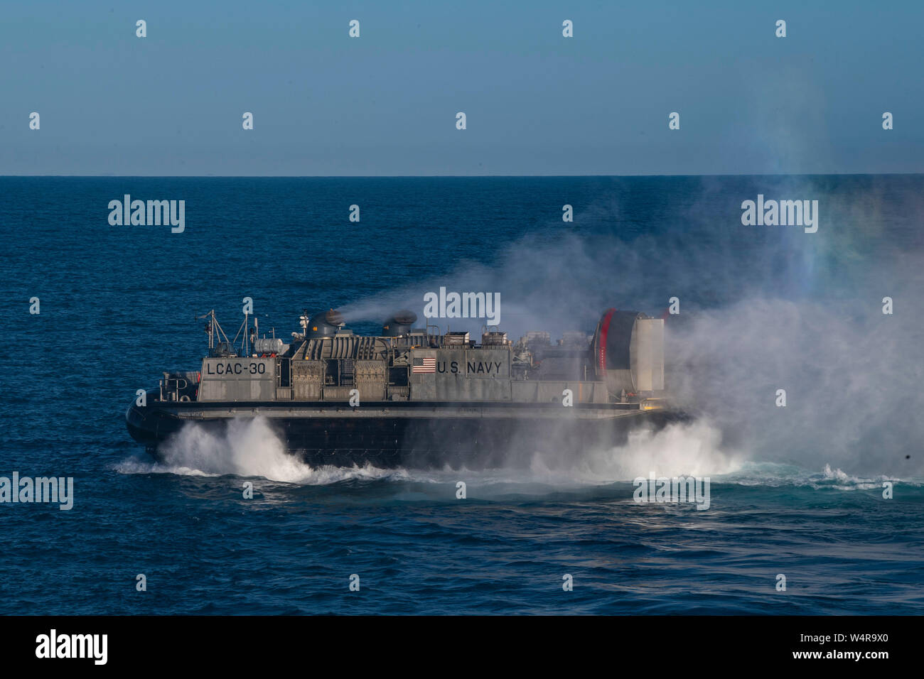 190724-N-BK435-0045 CORAL SEA (Luglio 24, 2019) - un arcobaleno appare come Landing Craft, cuscino d'aria (LCAC) 30, assegnato alla spiaggia navale unità (NBU) 7, si diparte la ben coperta dell'assalto anfibio nave USS Wasp (LHD 1). Wasp, ammiraglia di Wasp Expeditionary Strike gruppo, con avviato 31 Marine Expeditionary Unit, partecipa attualmente a Talisman Sabre 2019 al largo delle coste del nord Australia. Un accordo bilaterale, evento biennale, Talisman Sabre è progettato per migliorare NEGLI STATI UNITI Australia e combattere la formazione, la disponibilità e l' interoperabilità attraverso l' realistico, formazione pertinenti necessarie per mantenere ri Foto Stock