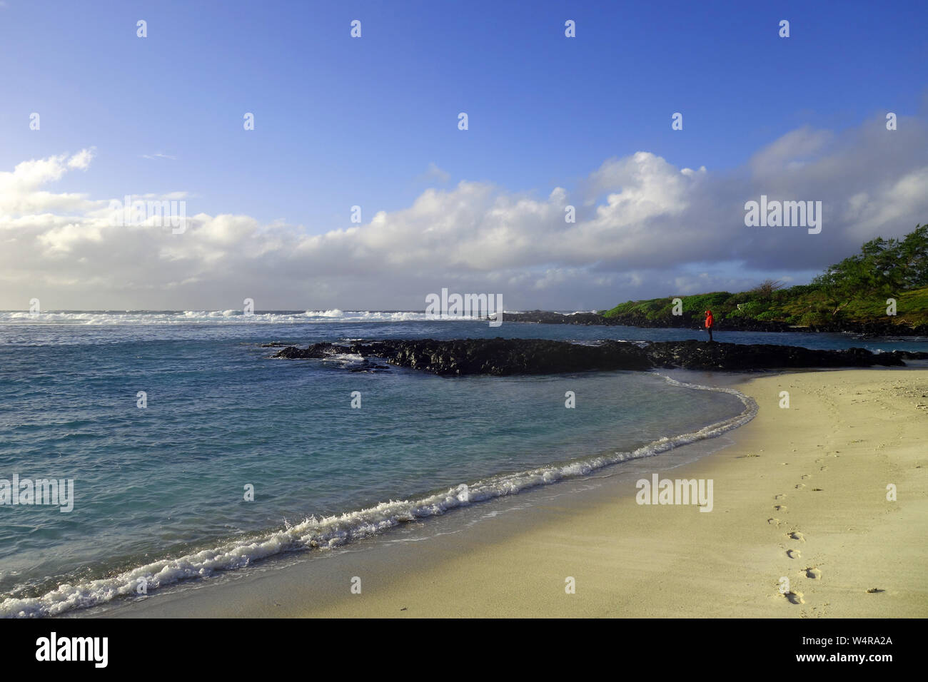Persona sulle rocce La Cambuse spiaggia pubblica, Mon Tresor, Mauritius. No signor Foto Stock