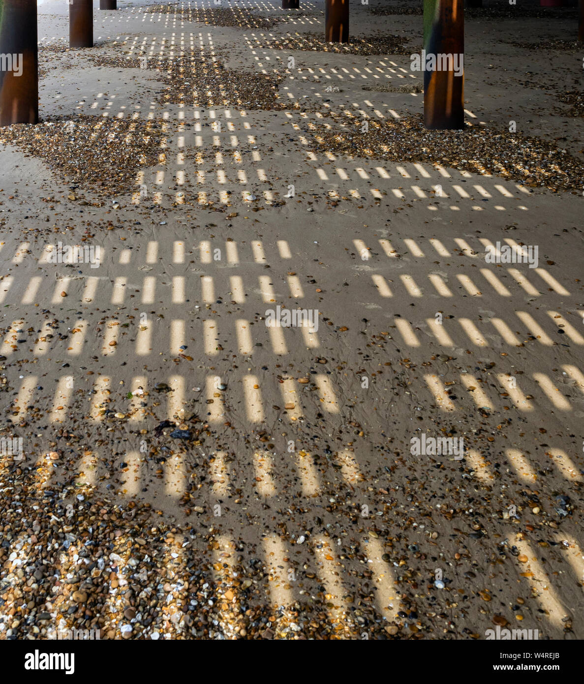FELIXSTOWE, ESSEX, Regno Unito - 18 LUGLIO 2018: Schemi d'ombra sulla spiaggia sotto il molo Foto Stock