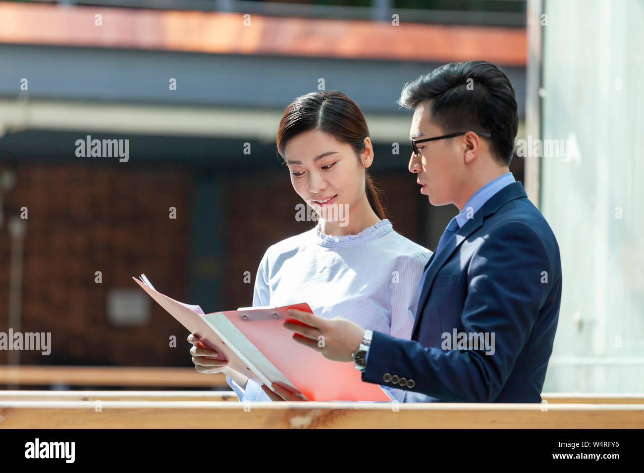 Donna e uomo azienda Apri cartella, Pechino, Cina Foto Stock